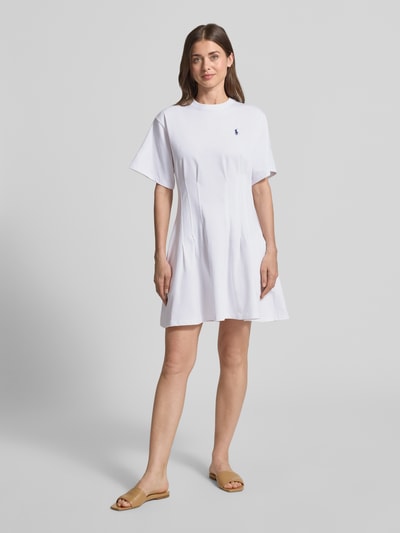 Frauenmodel trägt Leicht ausgestelltes Sweatkleid aus reiner Baumwolle von Polo Ralph Lauren in Weiß, Melange-Optik, Mini-Länge, Logo-Stitching, Kurzarm, gelegte Falten, Sweat, Ganzkörperansicht von vorne.