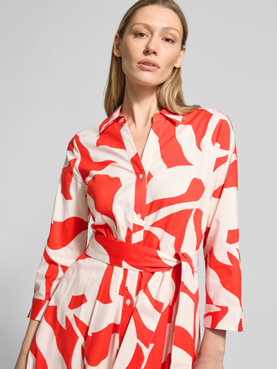 Frauenmodel trägt Midikleid mit Taillenband von More & More in Weiß-Rot, tailliert, Umlegekragen, Knopfleiste, 3/4-Arm, Nahaufnahme Oberkörper.