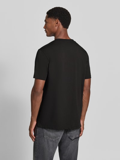 Männermodel trägt Regular Fit T-Shirt aus reiner Baumwolle Modell 'Diflow' von HUGO in Schwarz, glatte Oberfläche, Ganzkörperansicht Rückansicht. Herren T-Shirt von HUGO.