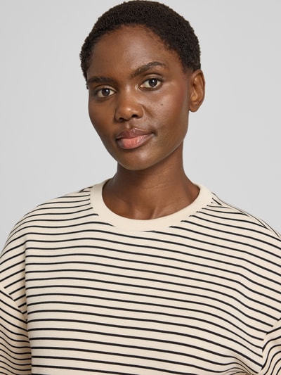 Kobieta modelka ma na sobie Oversized Fit T-Shirt aus Viskose-Mit od MSCH Copenhagen, kremowe w czarne paski, mieszanka wiskozy, okrągły dekolt, rękaw o dł. 1/2, długość tyłu w rozmiarze XS/S: 54 cm, zbliżenie na górną część ciała.