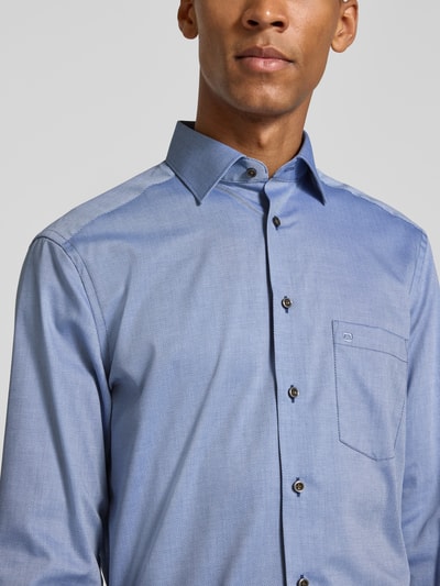 Männermodel trägt hellblaues Modern Fit Businesshemd aus reiner Baumwolle von OLYMP mit feiner Struktur, Nahaufnahme Oberkörper, Herren Businesshemd von OLYMP.