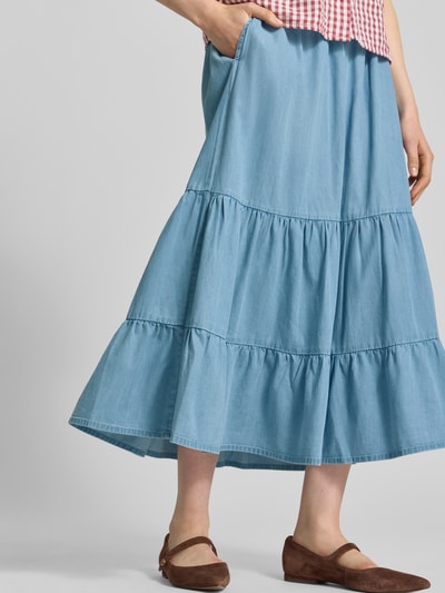 Frauenmodel trägt Midirock aus Lyocell-Mix in Denim-Optik von Christian Berg Woman, A-Linie, elastischer Bund, Raffungen, Nahaufnahme Unterkörper.