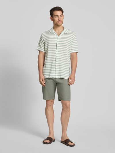 Männermodel trägt Relaxed Fit Poloshirt aus Baumwoll-Mix Modell 'DYLAN' von SELECTED HOMME, Optik:Allover-Muster, Ganzkörperansicht von vorne.