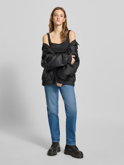 Frauenmodel trägt Straight Fit Jeans mit Logo-Patch Modell 'Mom' von Calvin Klein Jeans, niebieski denim, pięciokieszeniowy design, szerokość w rozmiarze 27/32: 36 cm, długość nogawki wewnętrznej w rozmiarze 27/32: 75 cm, widok całej sylwetki z przodu.