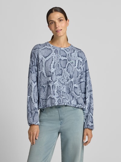Frauenmodel trägt Oversized Sweatshirt aus Baumwoll-Mix von Marc Cain, blau-graues Schlangenprint-Design, Ballonärmel, Nahaufnahme Oberkörper. Damen Sweatshirt, Rundhalsausschnitt, elastische Abschlüsse, Baumwoll-Mix.