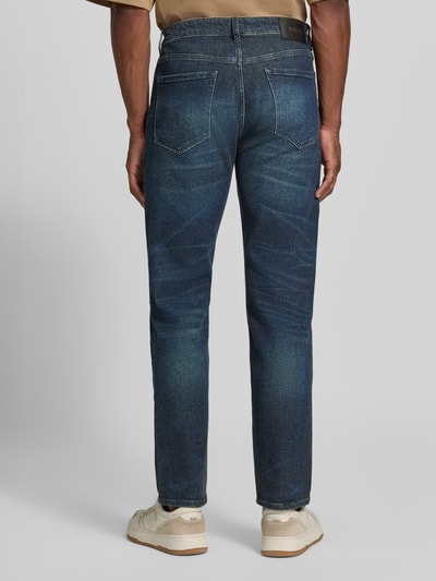 Männermodel trägt Straight Fit Jeans aus Baumwoll-Mix Modell 'C-Ogden' von BOSS in dunklem Blau mit deutlicher Waschung, Ganzkörperansicht Rückansicht. Herren Straight Fit Jeans von BOSS.