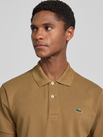 Männermodel trägt Regular Fit Poloshirt aus reiner Baumwolle Modell 'CORE' von Lacoste in Braun, Herren Poloshirt, Nahaufnahme Oberkörper.