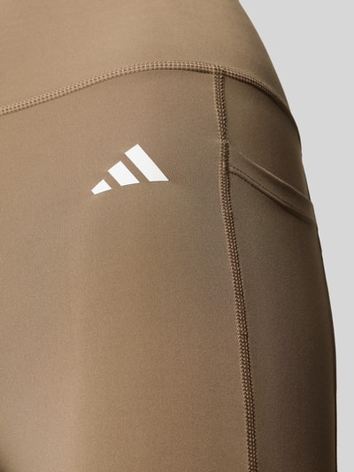 Produktfoto, Eng anliegende Sport-Leggings mit Logo-Print von adidas in Hellbraun mit glatter Textur, Kontext: Damen Sport-Leggings von adidas Training