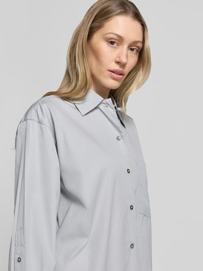 Frauenmodel trägt Oversized Hemdbluse aus reiner Baumwolle von Marc O'Polo in Hellgrau, Popeline, Kentkragen, Nahaufnahme Oberkörper.