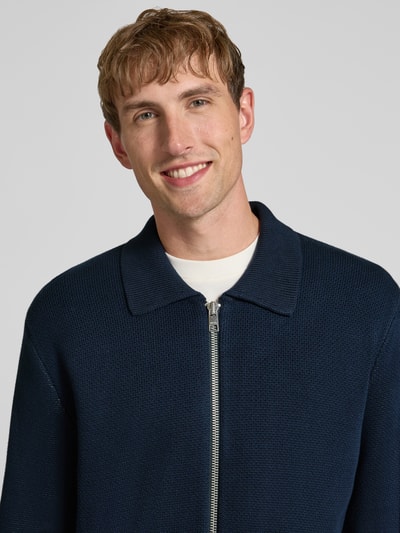 Männermodel trägt Regular Fit gebreid jack van puur katoen van Marc O'Polo DENIM in donkerblauw, Nahaufnahme Oberkörper.