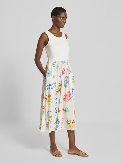 Frauenmodel trägt Midikleid mit Allover-Motiv-Print von Oui, taillierte Passform, Rundhalsausschnitt, ärmellos, Ganzkörperansicht von vorne.