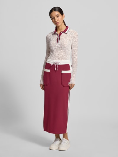 Frauenmodel trägt Slim Fit Longsleeve im semitransparenten Design von Marc Cain, weißer Spitzenstoff, Polokragen, Ganzkörperansicht von vorne.