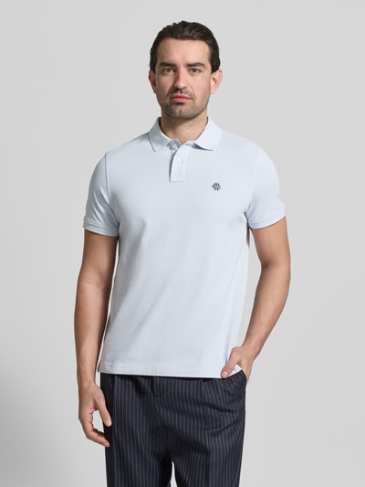 Männermodel trägt Slim Fit Poloshirt mit Logo-Stitching von MCNEAL aus reiner Baumwolle in Hellblau, Polokragen, Ganzkörperansicht von vorne.