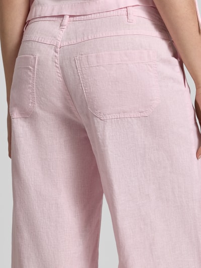Frauenmodel trägt Mid Waist Hose aus Leinen-Baumwoll-Mix von Gina Tricot in Rosa mit Eingrifftaschen, weitem Bein, Detailaufnahme Rückansicht.