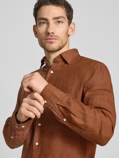 Männermodel trägt Slim Fit Business-Hemd aus Leinen mit Kentkragen von SEIDENSTICKER, braun, sichtbare Knopfleiste, Nahaufnahme Oberkörper, Rückenlänge 69 cm, Schulterbreite 43 cm, Ärmellänge 64 cm, Größe 40, reine Leinen-Textur.