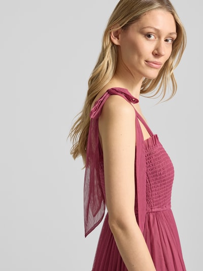Frauenmodel trägt Knielanges Cocktailkleid mit Smok-Details von LACE & BEADS aus Mesh in A-Linie und Stufen-Look, Nahaufnahme Oberkörper.
