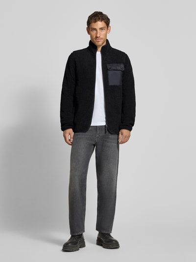 Männermodel trägt Regular Fit Jacke mit Stehkragen Modell 'Peter' von Didriksons, Schwarz, Strukturmuster, Ganzkörperansicht von vorne.