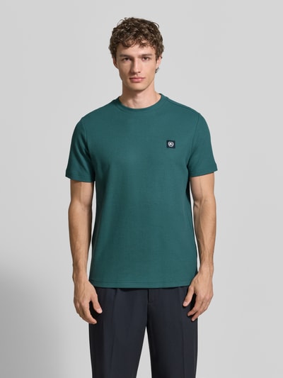 Männermodel trägt T-Shirt mit Label-Patch und Rundhalsausschnitt von Lerros in Dunkelgrün, Reine Baumwolle, Gerader-Schnitt, Ganzkörperansicht von vorne. Rückenlänge bei Größe M: 69 cm.
