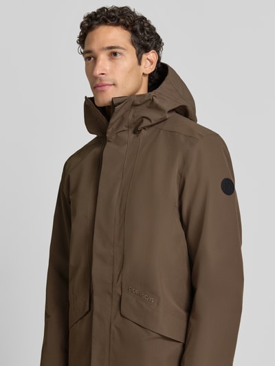Männermodel trägt Regular Fit Parka mit Kapuze Modell 'Kenny' von Didriksons in Braun, glatte Textur, Nahaufnahme Oberkörper. Herren Parka mit Eingrifftaschen, Rückenlänge 99 cm, Schulterbreite 48 cm, Brustweite 59 cm, Ärmellänge 72 cm.