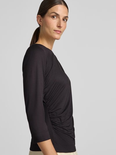 Frauenmodel trägt Regular Fit T-Shirt mit U-Boot-Ausschnitt von s.Oliver BLACK LABEL in Schwarz mit glatter, matter Struktur, Nahaufnahme Oberkörper.