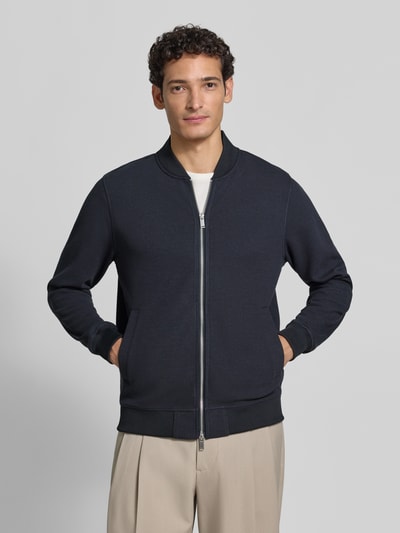 Männermodel trägt Sweatjacke mit Stehkragen von Christian Berg Men, dunkelblau, Baumwoll-Mix, seitliche Taschen, Ganzkörperansicht von vorne.