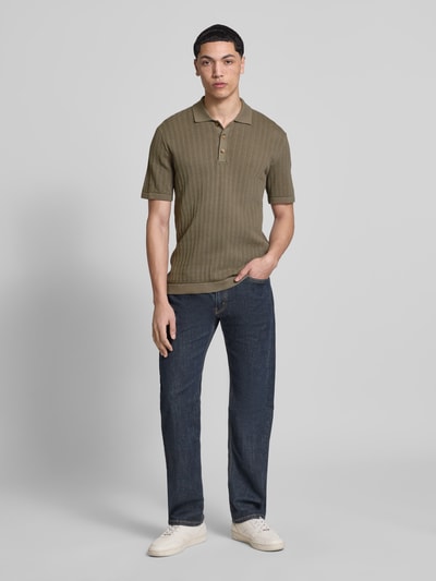 Männermodel trägt Regular Fit Poloshirt aus Baumwoll-Mix Modell 'MOON' von Only & Sons in Strickoptik, olivgrün, Ganzkörperansicht von vorne.