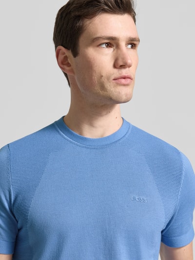Männermodel trägt Regular Fit T-Shirt aus Baumwoll-Mix Modell 'MOMENTUM-LITE' von BOSS Green in Optik: Unifarben mit Label-Print, Rundhals, Ärmelform: Kurzarm, Material: Baumwoll-Mix, Nahaufnahme Oberkörper.