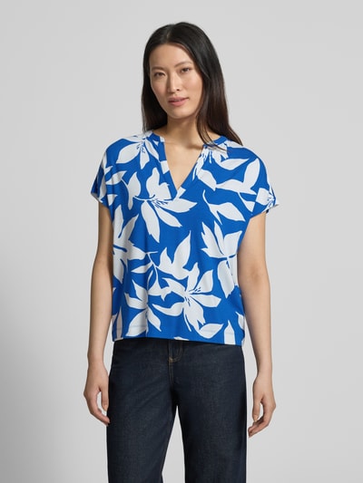 Frauenmodel trägt Relaxed Fit T-Shirt aus Viskose-Mix von s.Oliver RED LABEL mit Optik:Allover-Muster, floralem Muster in Blau und Weiß, Jersey-Material, Henley-Ausschnitt, Kurzarm, Ganzkörperansicht von vorne.