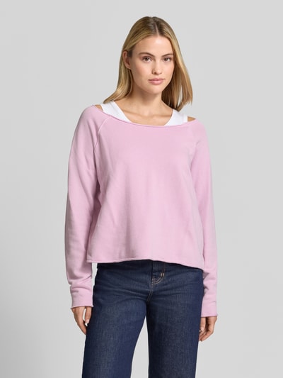 Frauenmodel trägt rosafarbenes Sweatshirt mit U-Boot-Ausschnitt Modell 'BTOWN' von American Vintage aus reiner Baumwolle, lockere Passform, Destroyed-Look am Saum, Ganzkörperansicht von vorne.