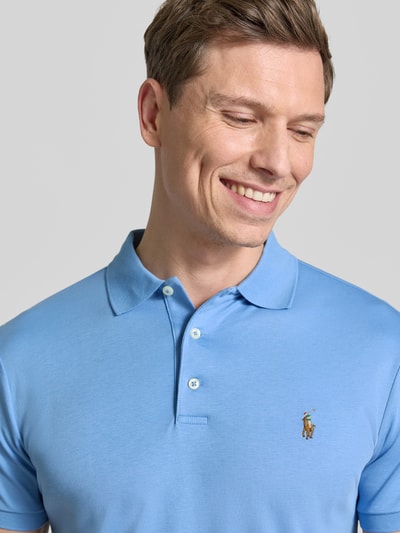 Männermodel trägt Regular Fit Poloshirt aus reiner Baumwolle von Polo Ralph Lauren in Hellblau mit Logo-Stitching, Nahaufnahme Oberkörper.