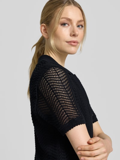 Frauenmodel trägt Leicht ausgestelltes Häkelkleid aus Baumwoll-Mix Modell 'C_ELOA' von BOSS Orange, Optik: Unifarben, Kurzarm, schwarze Häkelspitze, Polokragen, V-Ausschnitt, Unterkleid, Mini-Länge, Nahaufnahme Oberkörper.