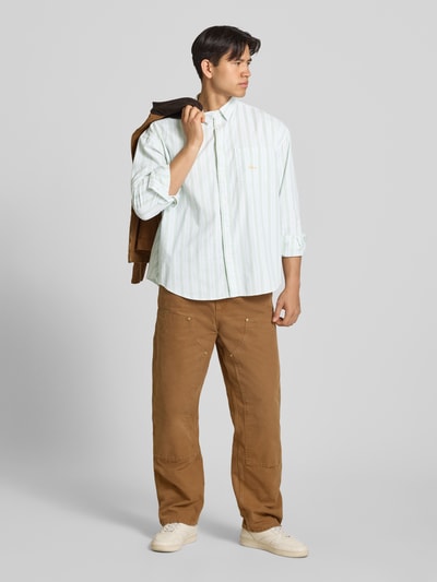 Männermodel trägt Regular Fit Freizeithemd mit Brusttasche von BLKVIS in lichtgroen-wit gestreept, katoenmix, borstzak, lange mouwen, kentkraag, logo-stiksel, volledige lichaamsaanzicht van voren.