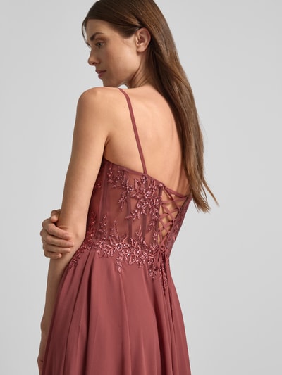 Vrouwenmodel draagt avondjurk met siersteentjes van Luxuar, tule, getailleerde pasvorm, mouwloos design, bloemenborduursel, hartvormige hals, maxilengte, onderrok, naadritssluiting, semi-transparante delen, ruglengte maat 36: 160 cm, borstwijdte maat 36: 36 cm. Detailopname rug.