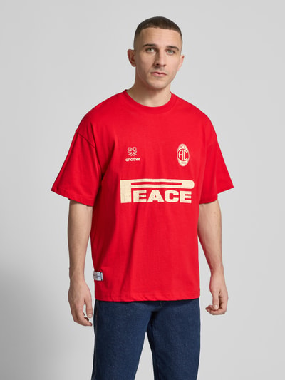 Männermodel trägt Regular Fit T-Shirt mit Logo-Print von ANOTHER COTTON LAB in Rot, reine Baumwolle, Rundhalsausschnitt, Ganzkörperansicht von vorne.