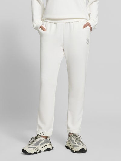 Frauenmodel trägt Sweatpants mit elastischem Bund und Logo von LIU JO SPORT in Weiß, Modal-Mix mit Stretch-Anteil, Regular-Fit, Logo links, Damen Sweatpants, Ganzkörperansicht von vorne.