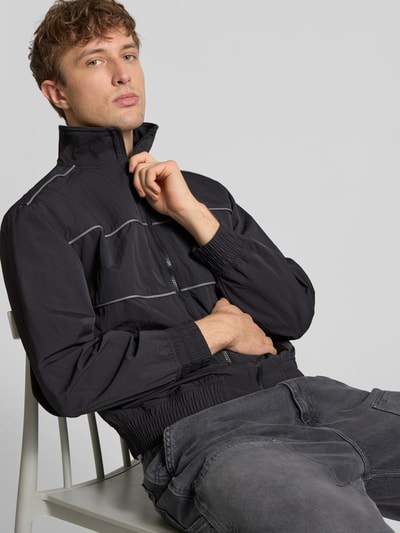 Männermodel trägt Regular Fit Blouson mit Kontraststreifen Modell 'HEIGHTS PIPPING JACKET' von Levi’s®, unifarben, Stehkragen, Nahaufnahme Oberkörper.
