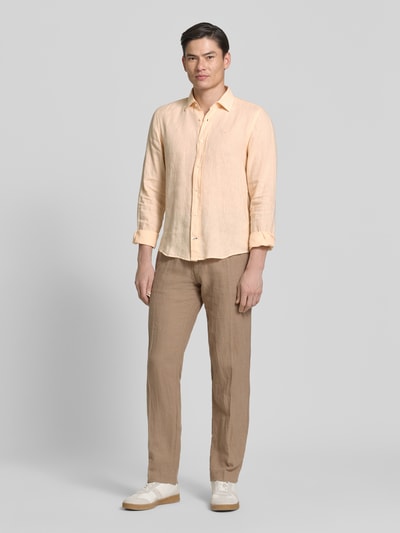 Männermodel trägt Causal Fit Leinenhemd mit Kentkragen Modell 'Mike' von JOOP! Collection in Beige, reine Leinen, abgerundeter Saum, Ganzkörperansicht von vorne. Rückenlänge bei Größe M: 73 cm, Schulterbreite: 40 cm, Ärmellänge: 66 cm, sportliche Knopfleiste und Sportmanschetten, weiche Textur.