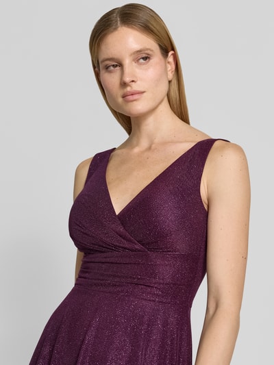 Frauenmodel trägt Knielanges Cocktailkleid mit V-Ausschnitt von TROYDEN COLLECTION aus Chiffon, Taillierter Schnitt, Breite Träger, Nahaufnahme Oberkörper.