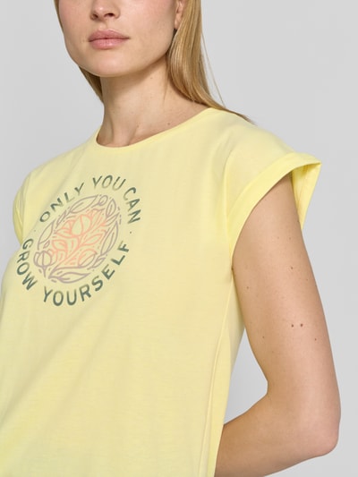 Frauenmodel trägt Damen T-Shirt mit Statement-Print von G.I.G.A. DX in sanftem Gelb, Regular-Fit, Baumwoll-Mix, Rundhalsausschnitt, Nahaufnahme Oberkörper, Rückenlänge Größe 36: 61 cm.