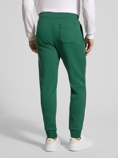Männermodel trägt Tapered Sweatshorts aus Baumwoll-Mix von Polo Ralph Lauren in Optik: Unifarben mit Logo-Stitching und seitlichen Eingrifftaschen, Materialverarbeitung: Sweat, Passform: Tapered, Ganzkörperansicht Rückansicht.