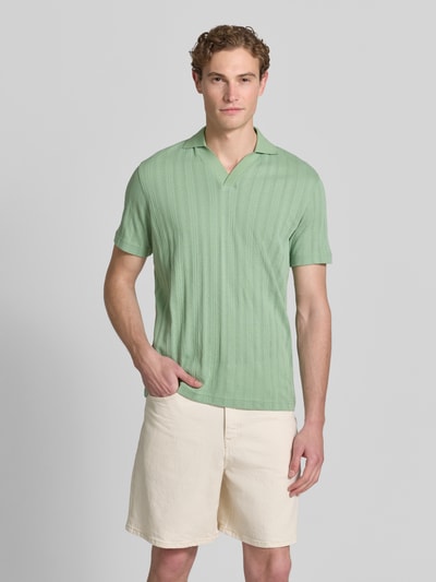 Männermodel trägt Regular Fit Poloshirt aus Baumwoll-Mix Modell 'TRAVIS' von SELECTED HOMME, Optik: Unifarben, Struktur, Jacquard, Ganzkörperansicht von vorne.