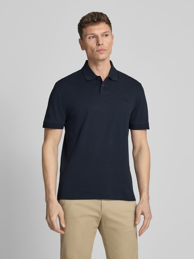 Männermodel trägt Regular Fit Poloshirt aus reiner Baumwolle Modell 'INTERLOCK' von BOSS Orange, Optik: Unifarben, Ganzkörperansicht von vorne.