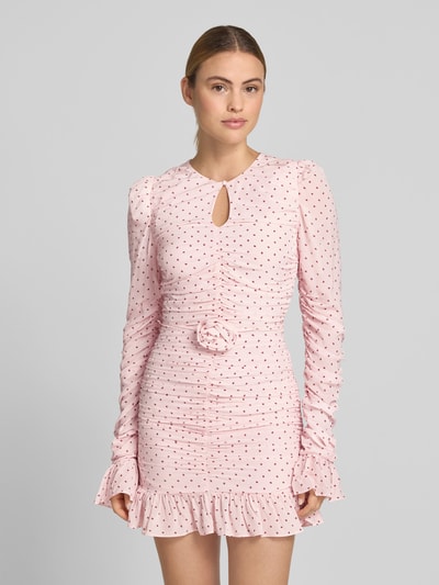 Frauenmodel trägt Slim Fit Minikleid aus reiner Viskose von ROTATE mit Raffung, floralem Besatz, langärmelig, rosa, Punktemuster, Ganzkörperansicht von vorne. Gesamtlänge bei Größe 36: 80 cm, Brustweite: 43 cm, Ärmellänge: 97 cm.