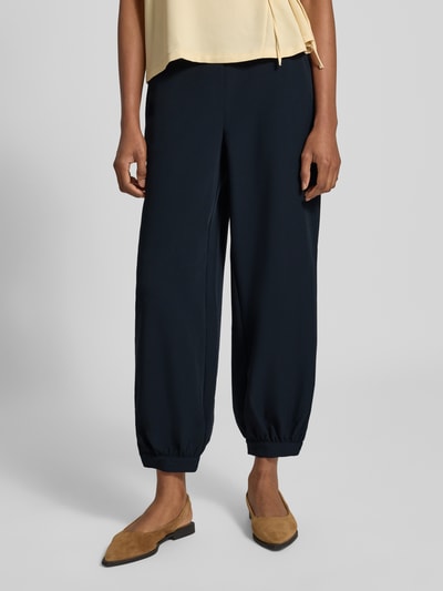 Frauenmodel trägt Weite Hose mit Viskose-Anteil Modell 'Myha balloon' von OPUS, dunkelblau, locker geschnitten, Damen Weite Hose, Nahaufnahme Oberschenkel bis Füße.