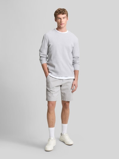 Männermodel trägt Regular Fit Chinoshorts aus Baumwoll-Mix von Tom Tailor Denim in Bi-Color Optik, seitliche Eingrifftaschen, Ganzkörperansicht von vorne.