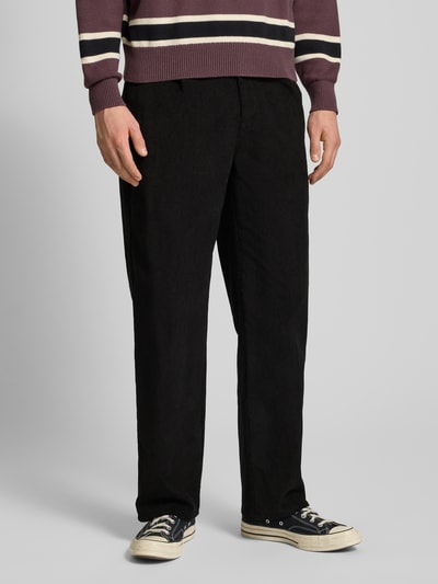 Männermodel draagt Corduroy broek met achterzakken Model 'Script' van BLKVIS, puur katoen, wijd been, kleur zwart, nahaufnahme onderlichaam.