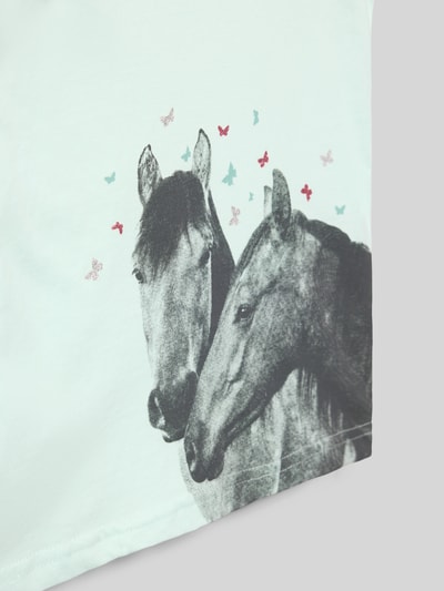 Mädchen trägt T-Shirt mit Motiv-Print und Rundhalsausschnitt von Blue Seven, Reine Baumwolle, Regular-Fit, Nahaufnahme Oberkörper.