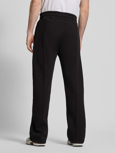 Männermodel trägt Loose Fit Sweatpants mit Labelstitching und elastische band van PROHIBITED, katoenmix, heren, binnenbeenlengte maat M 80 cm, ganzkörperansicht rückansicht