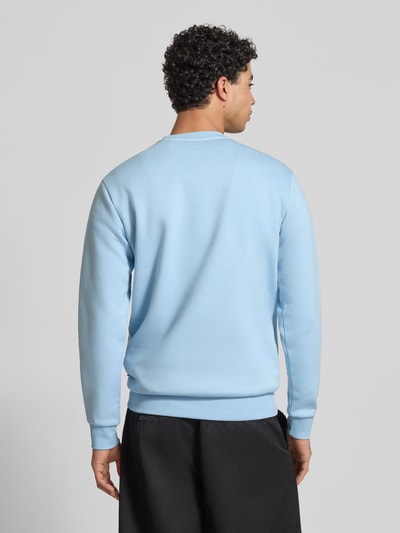 Männermodel trägt Regular Fit Sweatshirt aus Baumwoll-Mix Modell 'CERES' von Only & Sons in Hellblau, unifarben, Ganzkörperansicht Rückansicht.