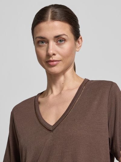 Vrouwenmodel draagt Regular Fit T-shirt uit linnenmix met V-hals en gaatjesmotief van Scotch & Soda, ruglengte bij maat S 62 cm, close-up bovenlichaam